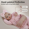 A hand-painted pink baby doll with lifelike features and natural tones.