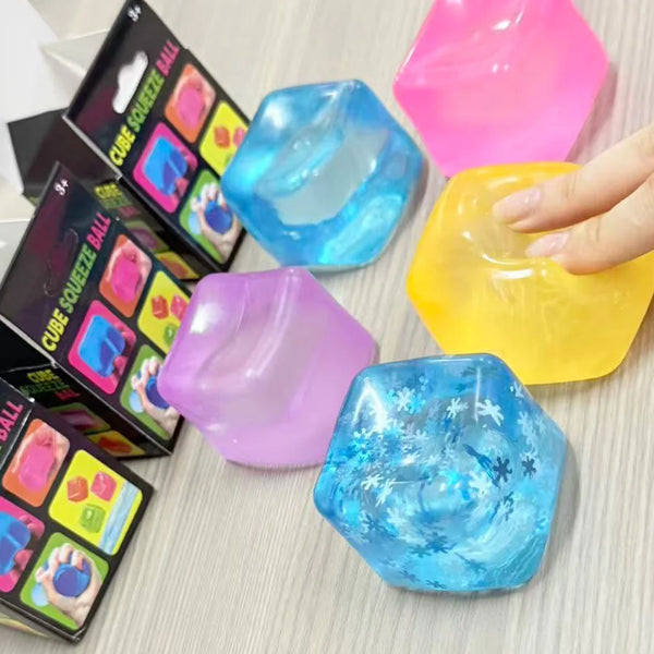 A hand holds and squeezes various colored, translucent stress cube squish toys.