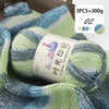 A close-up of a light blue and green gradient acrylic yarn skein used for knitting or crochet.