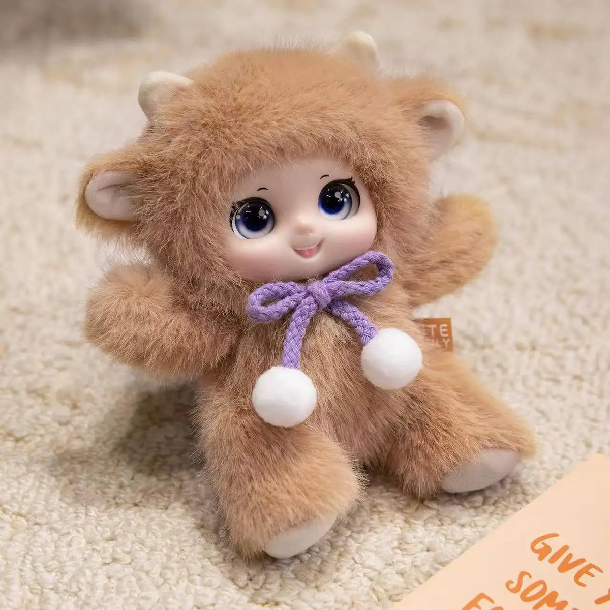 A fluffy brown plush pendant featuring a cute animal face design resembling a rabbit or bear.