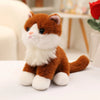 An adorable sitting kitten plush doll with orange and white fur, looking to the side.