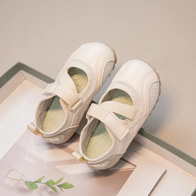 A pair of white girls' casual slip-on shoes with a breathable PU upper resting on a light surface.