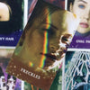 A close-up of a card from the Twin Flame Love Oracle Deck featuring a woman's face with a rainbow light effect and freckles.