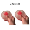 Une paire de balles anti-stress roses en forme de fraises, tenues dans les mains d'une personne.