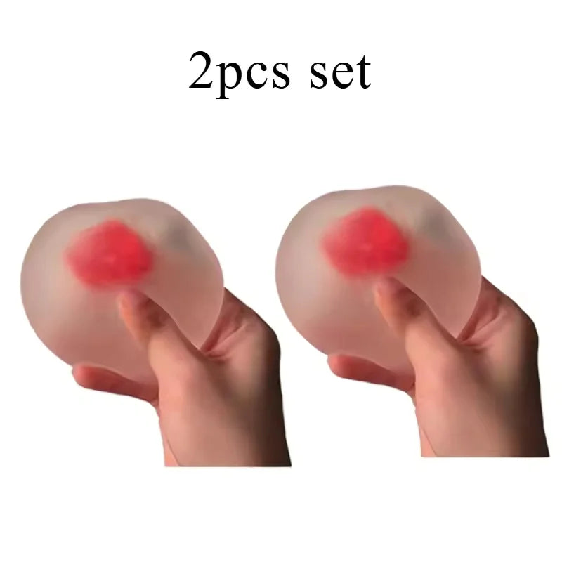 Une paire de balles anti-stress roses en forme de fraises, tenues dans les mains d'une personne.
