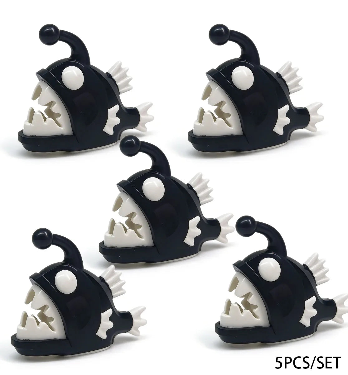 Five black plastic shark building blocks with white teeth and eyes in a set