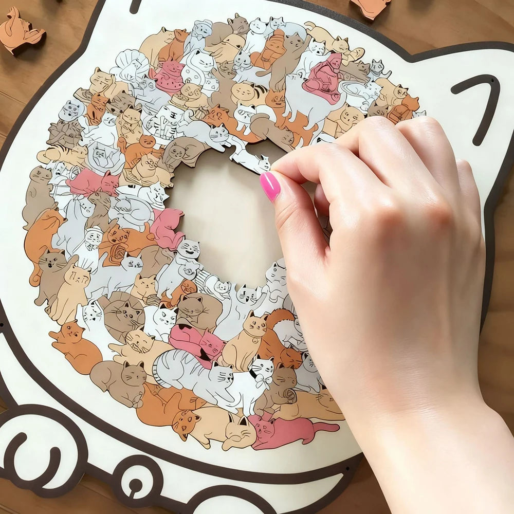 A hand places a pink fingernail on a wooden jigsaw puzzle shaped like a cat, featuring numerous small cats in various colors.