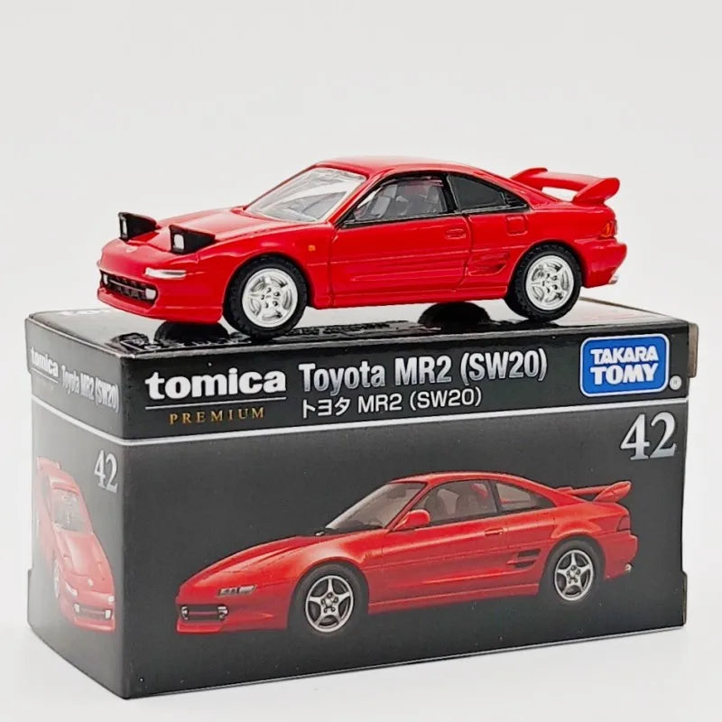 A red Tomica Toyota MR2 (SW20) die-cast sports car model in its packaging.