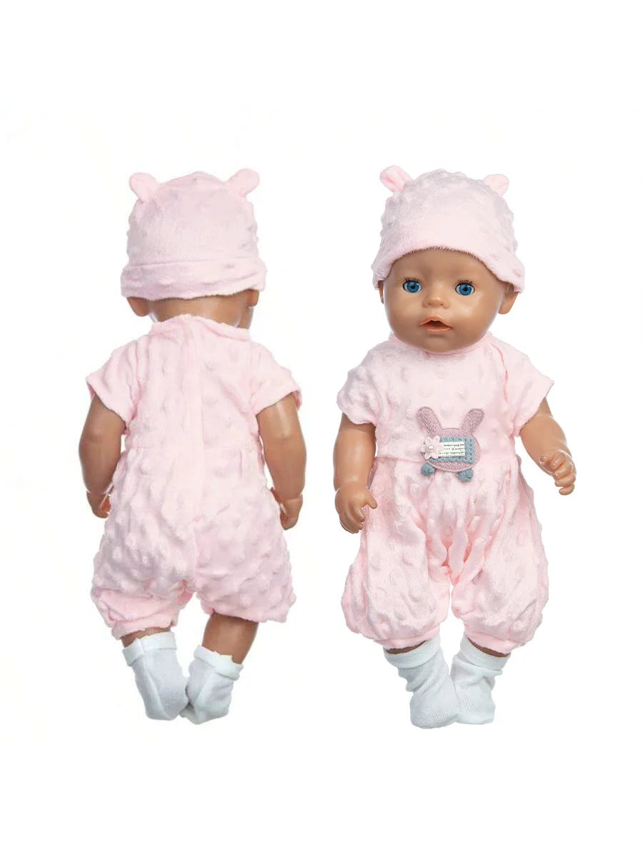 A baby doll wearing a pink outfit and a matching pink hat with a cat print shirt.
