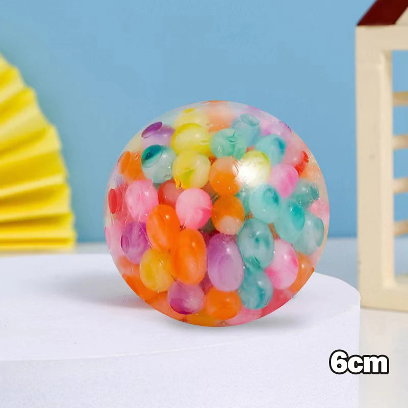 A sphere of colorful, translucent stress relief balls with a mesh netting, displayed on a white surface.