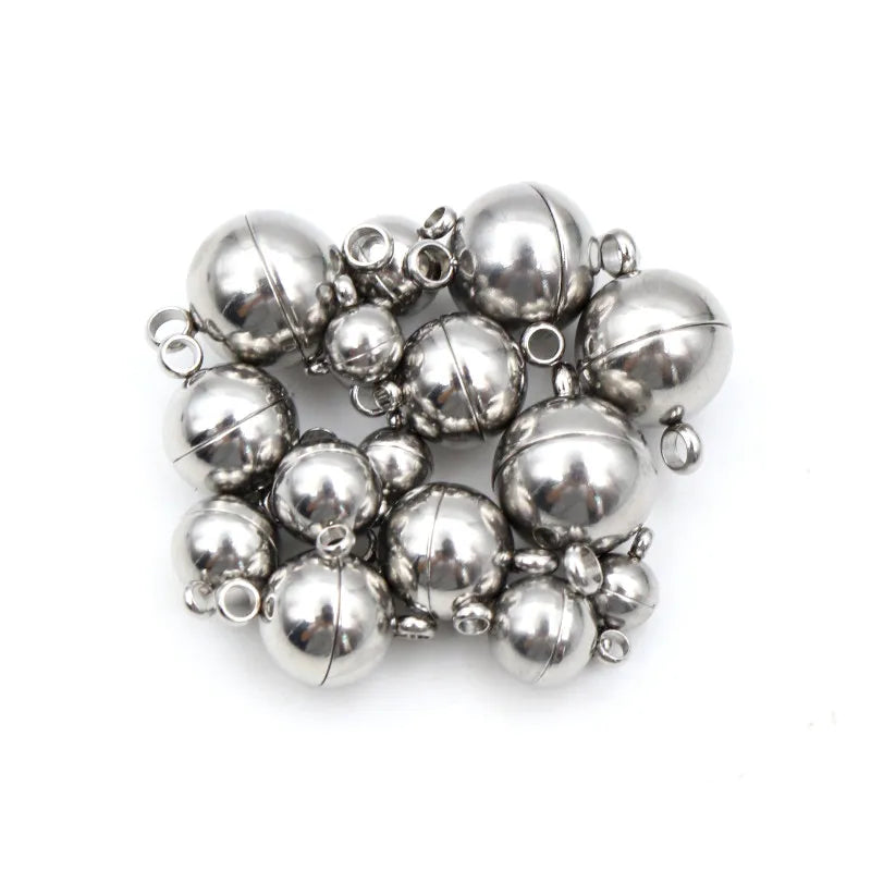 A cluster of small, spherical stainless steel magnetic clasps for jewelry making.