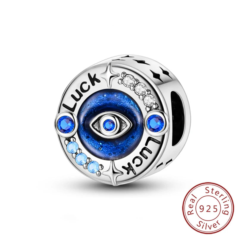 Sterling silver charm bead featuring a central blue eye design surrounded by luck and angel motifs