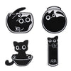 A set of four black cat enamel pins featuring different styles and designs.