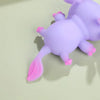 A purple axolotl squishy toy with pink accents resting on a light green surface.