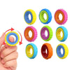 A hand holds a set of colorful sensory fidget rings for stress relief and focus.