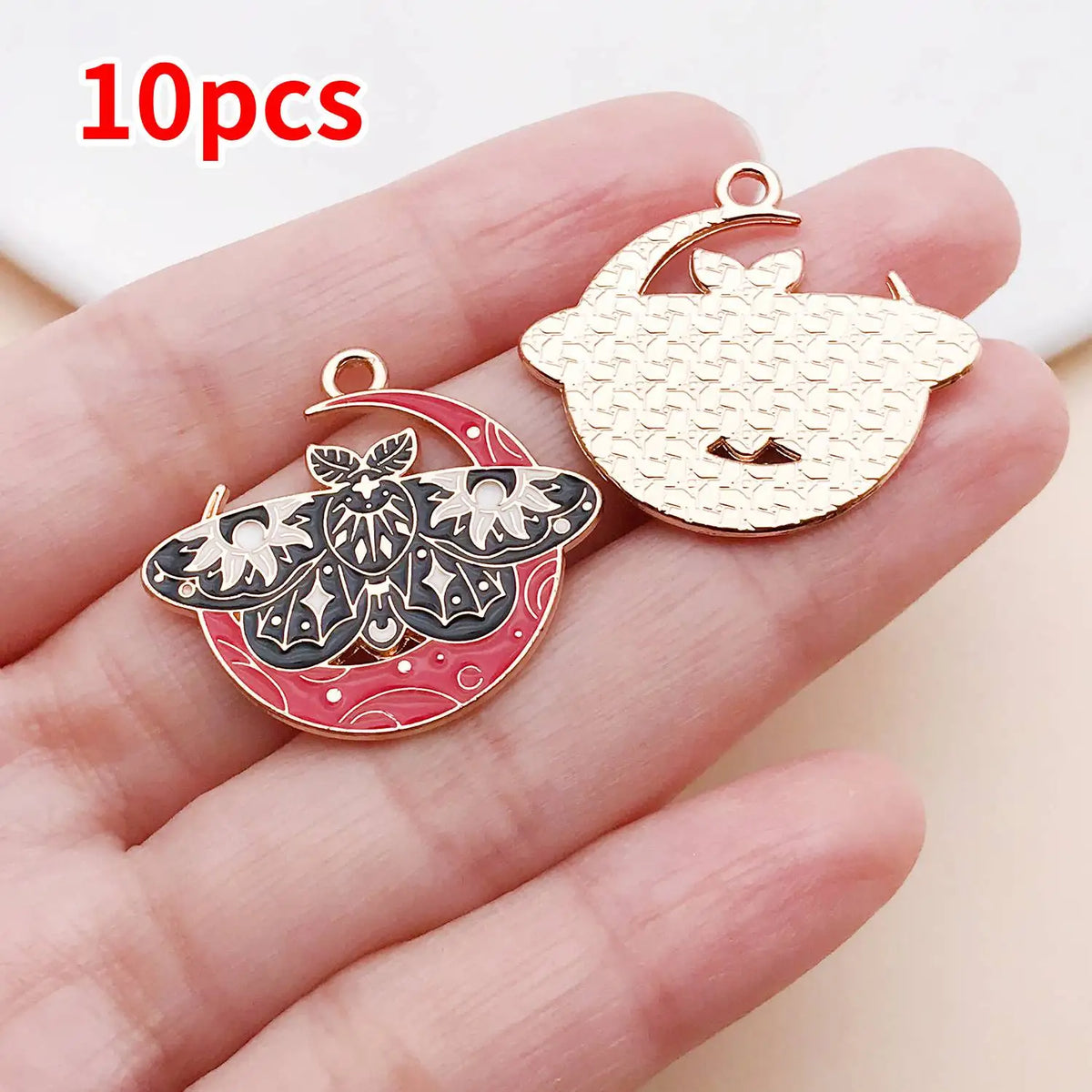 Ten gold-toned butterfly drop charms are displayed on a hand, showing their intricate designs.