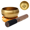 A handcrafted Tibetan singing bowl with a silk cushion and wooden mallet shown next to the bowl and a separate gong.