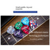 A variety pack of small guitar picks in different colors and thicknesses resting on a wooden guitar fretboard.