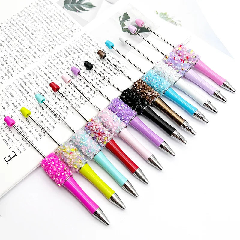 A collection of twelve pack diamond sequins bead ballpoint pens in various colors and finishes arranged on a white background
