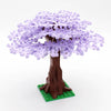 A model of a cherry blossom tree built from purple LEGO bricks standing on a green base.
