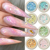 A collection of iridescent opal and mermaid chrome nail glitter pigments in small pots, shown alongside finished nails.