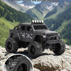 A black off-road RC car with large tires and LED lights is positioned on a rocky outdoor terrain.