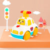 A yellow and white light-up gear car toy for toddlers is displayed on an orange surface next to a traffic light.