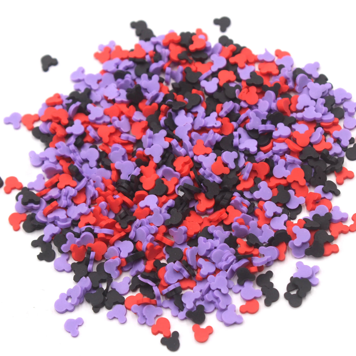 A pile of small, colorful polymer clay slices in red, purple, and black for slime and craft projects.