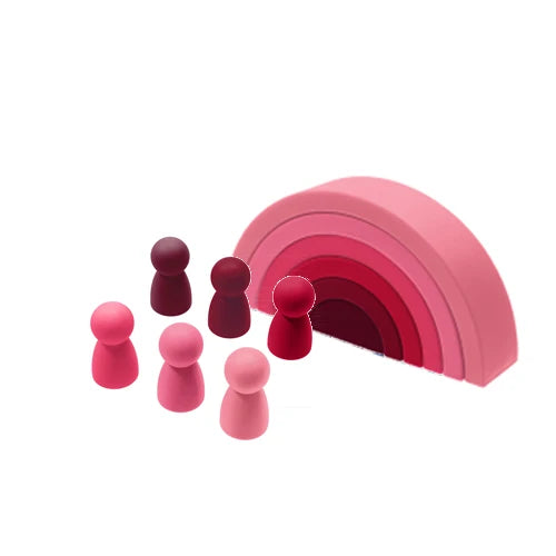 A set of soft silicone rainbow building blocks in various shades of pink and red, arranged in a curved formation.