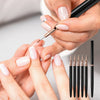 Hands applying ultra-fine nail art liner brushes for detailed manicure work.