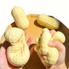 A hand holds a yellow peanut butter squishy stress ball fidget toy on a wooden tray.