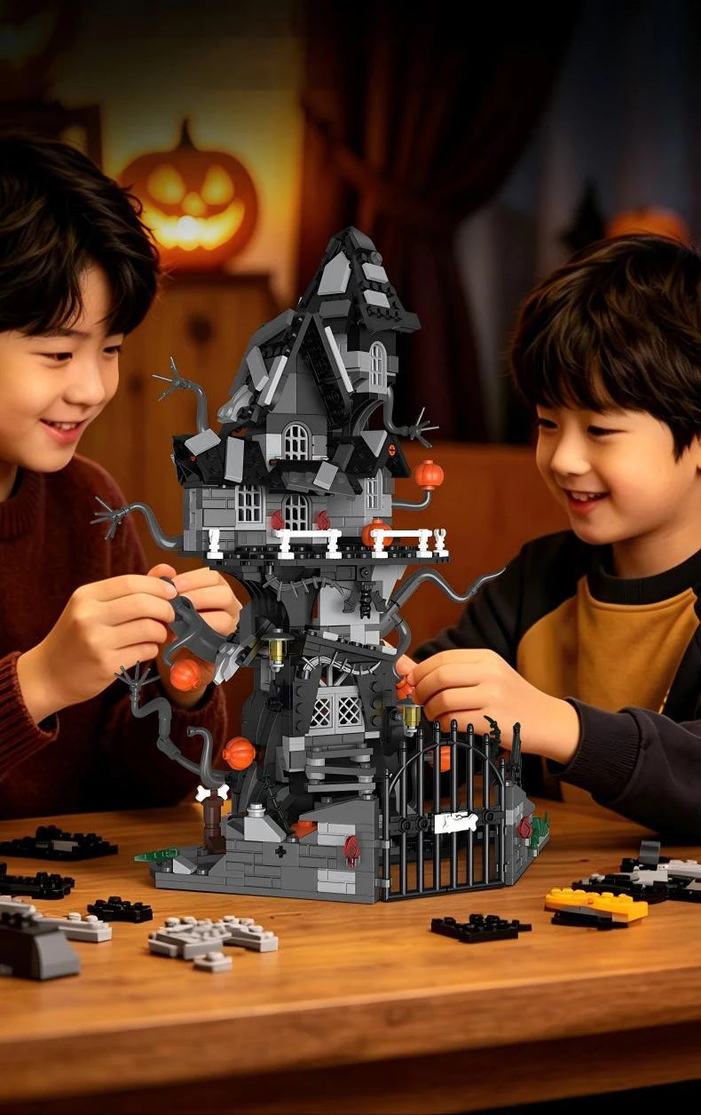 Two young boys build a detailed spooky Halloween castle structure using gray and black building blocks on a wooden table.