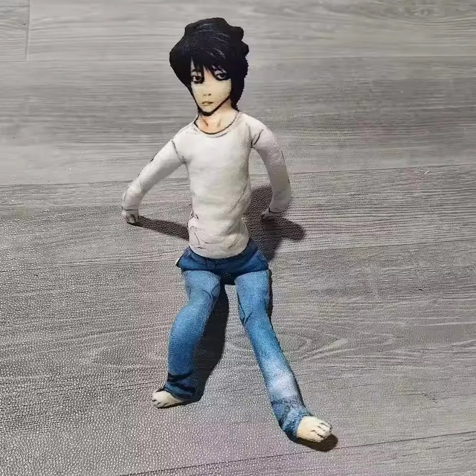 A dark-haired anime-style plush doll resembling L Lawliet from Death Note, wearing a light gray shirt and blue jeans.