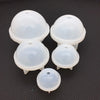 Four white silicone sphere molds for resin crafting arranged on a dark surface.