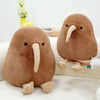 A brown kiwi bird plush toy with a large beak sitting on a white surface.