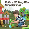 A young boy is building a 3D Mag-World structure using magnetic building tiles on a green surface.