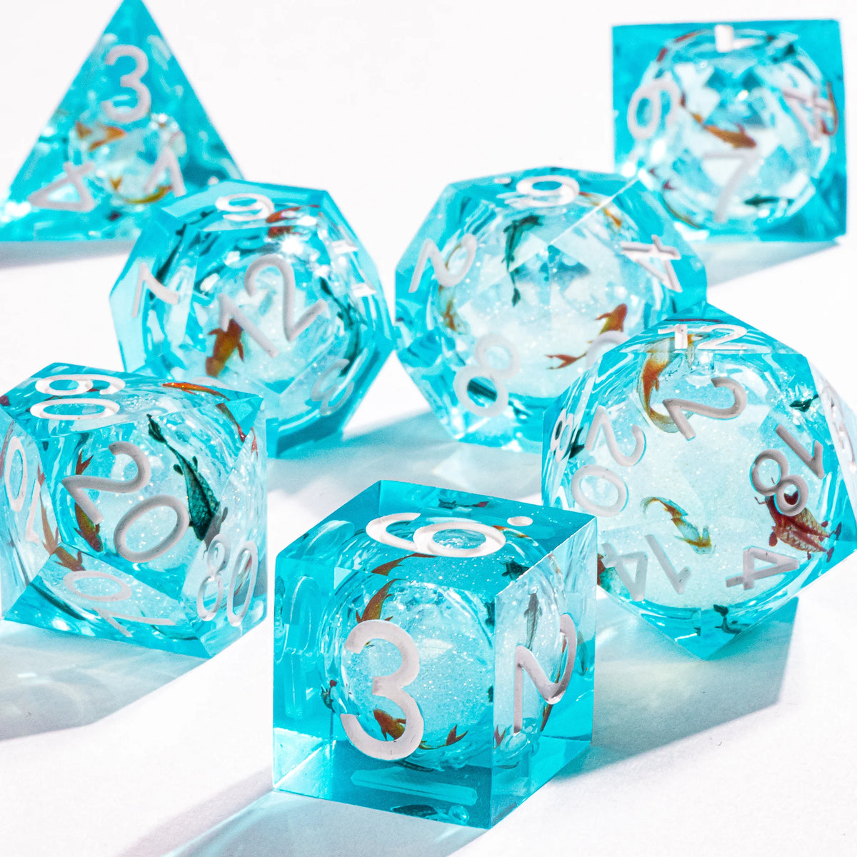 A collection of bright blue liquid core polyhedral dice showing various numbers and a galaxy finish.