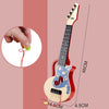 A red ukulele toy with a light blue body and a neck, showing dimensions and a hand pulling a string.