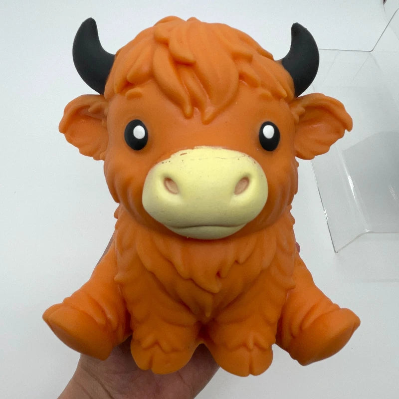 An orange jumbo highland cow squishy stress ball fidget toy with black horns.