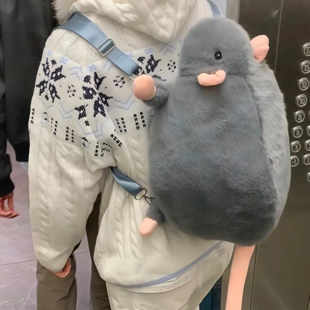 A gray plush rat with pink ears is being held by a person wearing a white coat.