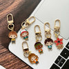 A set of six metal keychains featuring character pendants from Stranger Things, including a doll and various characters.