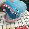 A blue shark-themed prank board game featuring a large plastic mouth and teeth, displayed on a white surface.