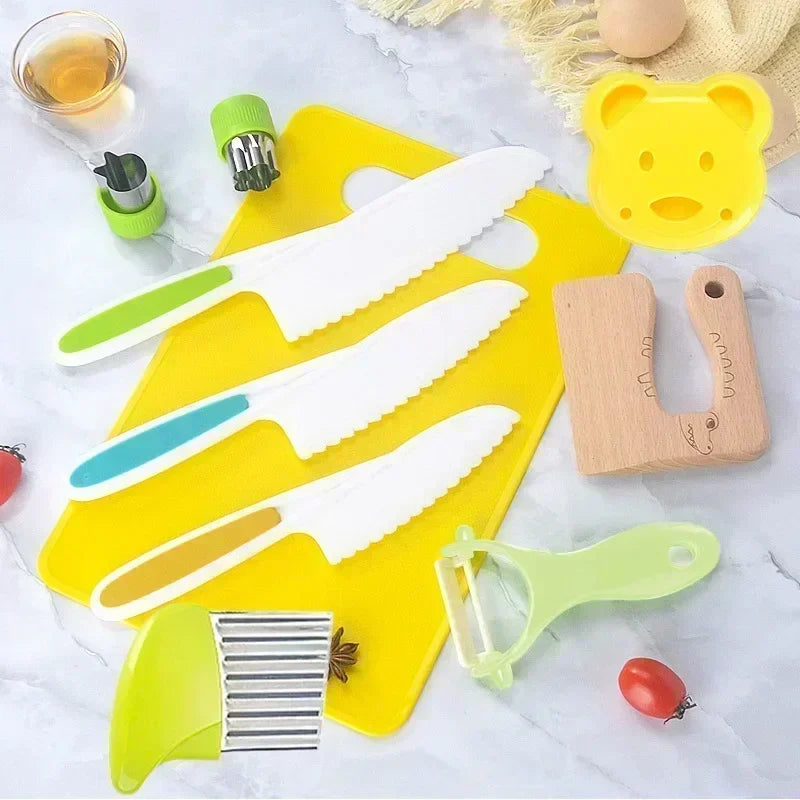 A yellow cutting board holds a set of colorful plastic knives and kitchen tools for kids.