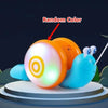 A musical pull-along snail toy with a random color light shining on the front, displayed on a round platform.