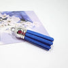 A set of blue velvet tassels with silver metal findings displayed on a light purple background.