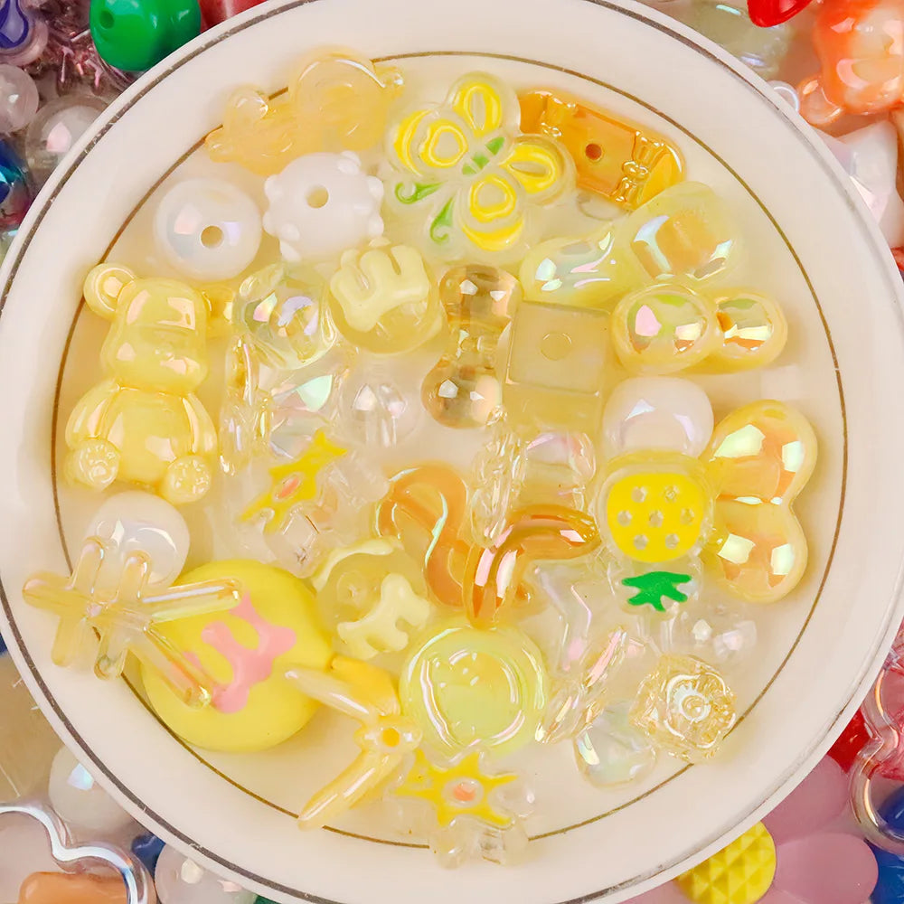 A collection of yellow and clear acrylic bow and flower beads for DIY jewelry making