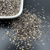 Crushed glass mix for resin and jewelry making scattered on a dark surface.
