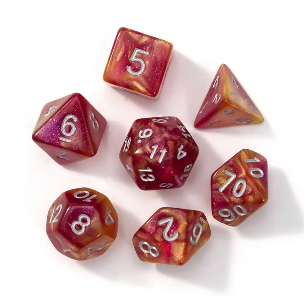 A set of seven polyhedral acrylic dice in various colors and shapes scattered on a white surface.
