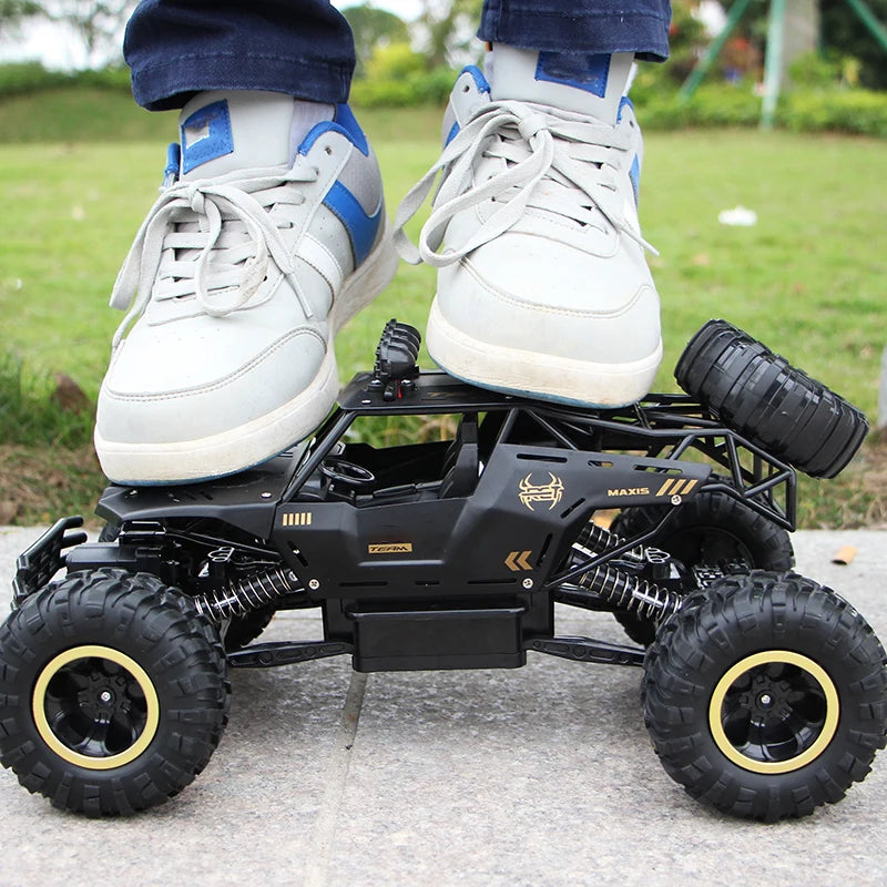 A white and blue high-speed 4WD off-road RC truck with large tires is shown on a concrete surface.
