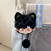 A black cat-shaped plush pendant keychain with green accents hanging from a light blue fabric strap.